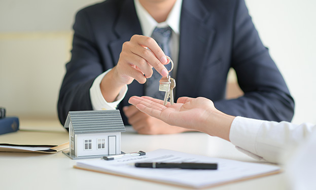 A realtor handing off the keys to a home to a client
