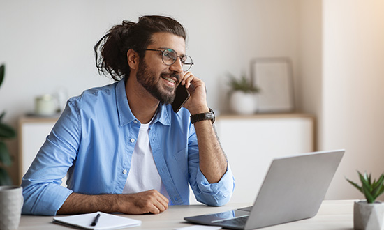 A person on the phone working in their home office