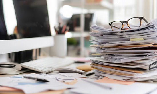 A stack of documents on a home office desk