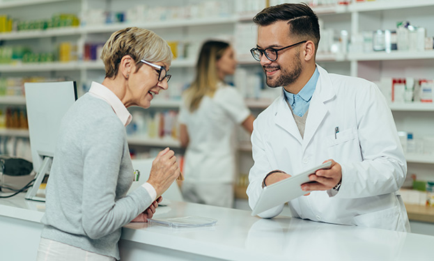 A pharmacist talking with a client at a counter
