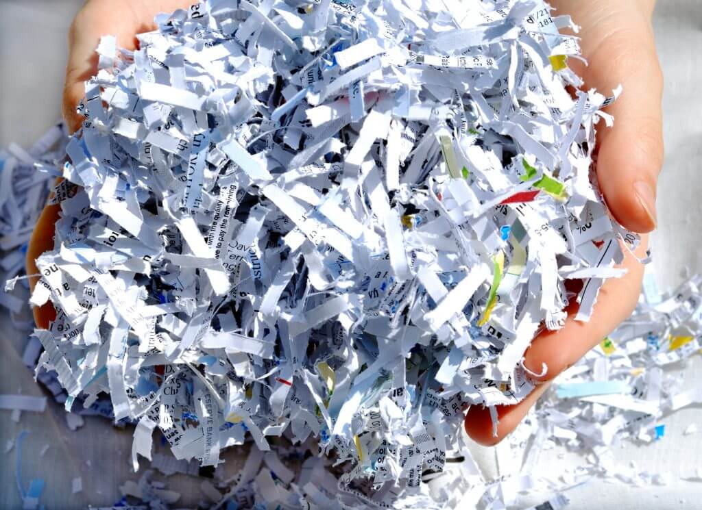 A person holding shredded paper in their hands